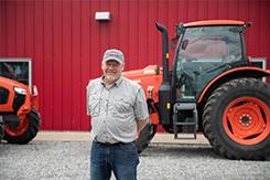 Man standing in front of farm equipment