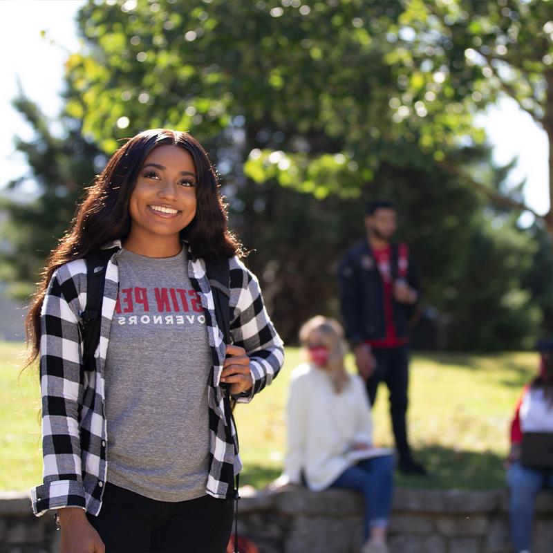 Student poses for photo walking on campus