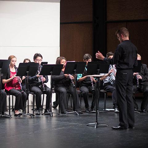 Music student conducts ensemble during performance